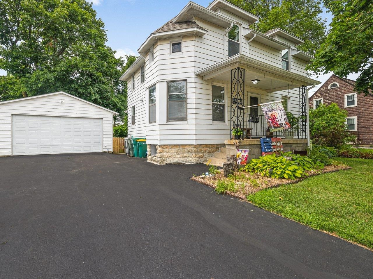 a view of a house with a small yard and a large tree