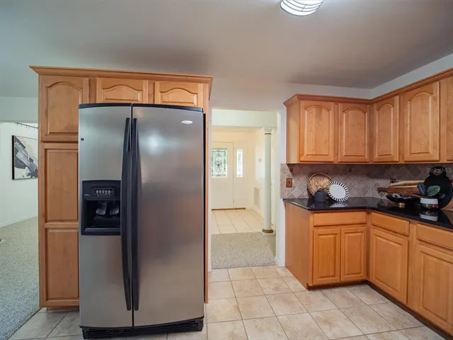 a kitchen with stainless steel appliances granite countertop a refrigerator and a stove