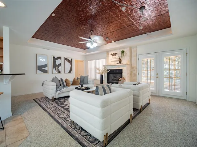 a living room with furniture a fireplace and a chandelier