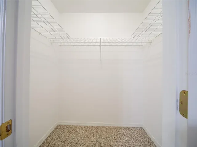 an empty room with a fan & a window