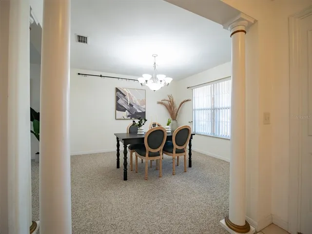 a view of a dining room with furniture and chandelier