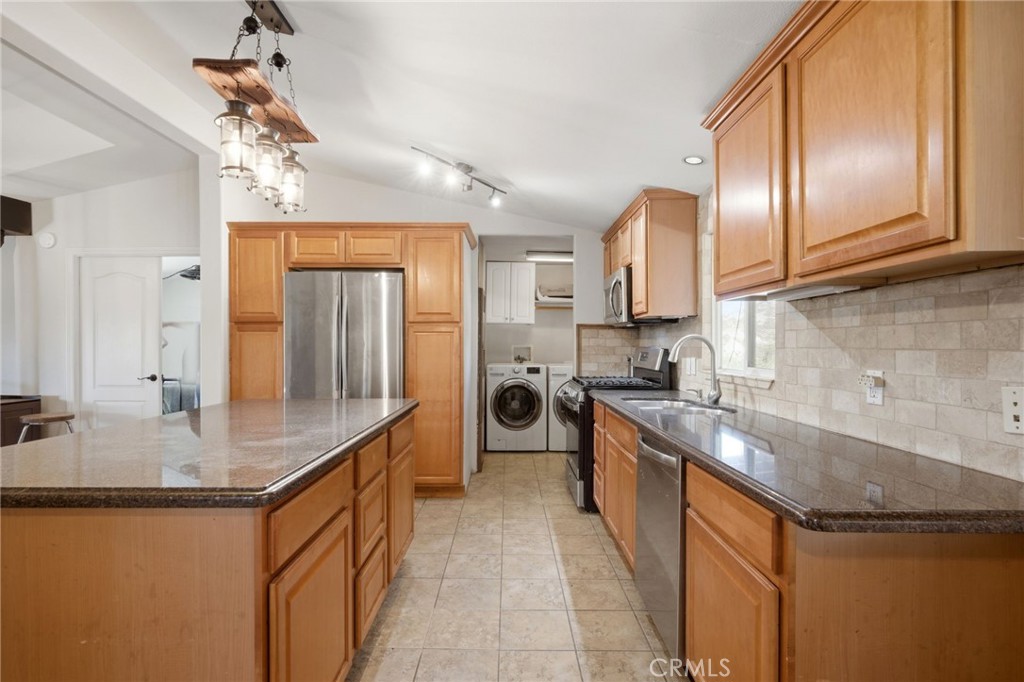 40100 Owl Valley Road Temecula, CA 92592 - Photo 26 of 44 a kitchen with stainless steel appliances granite countertop a sink a stove and a wooden cabinets