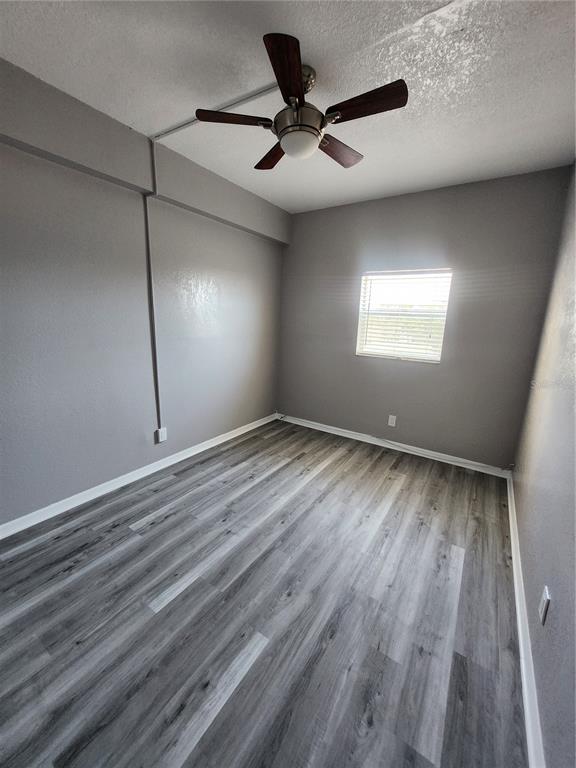 5541 Bay Boulevard, Unit 403 Port Richey, FL 34668 - Photo 11 of 24 wooden floor in an empty room with a window