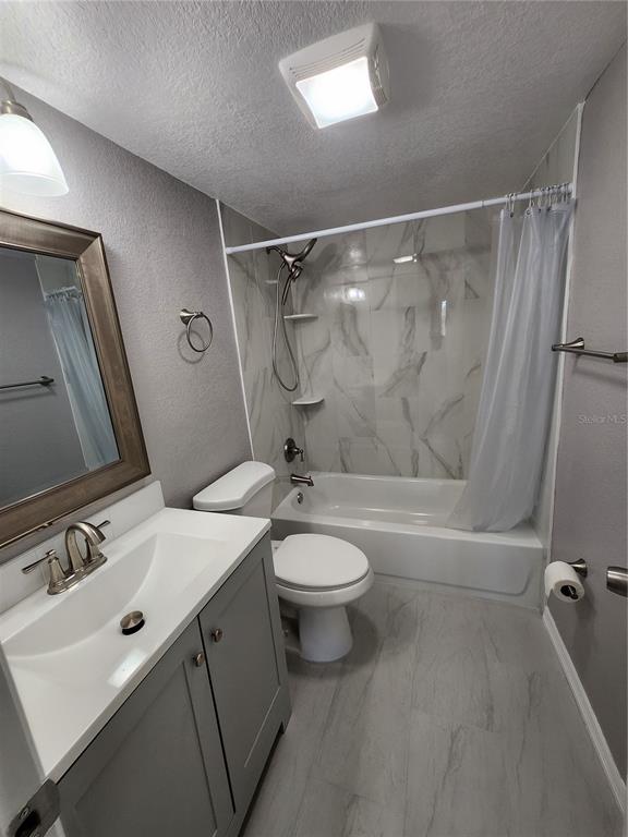5541 Bay Boulevard, Unit 403 Port Richey, FL 34668 - Photo 12 of 24 a bathroom with a sink a toilet and shower