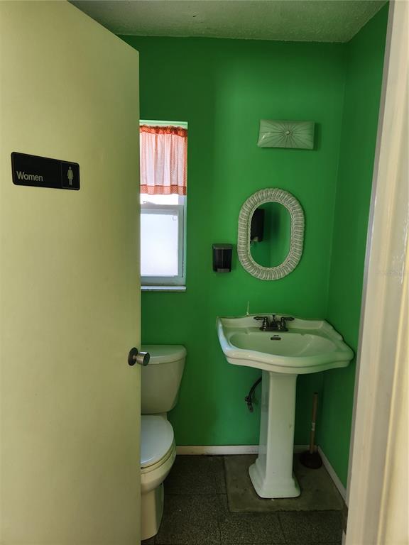 5541 Bay Boulevard, Unit 403 Port Richey, FL 34668 - Photo 21 of 24 a bathroom with a sink toilet and mirror