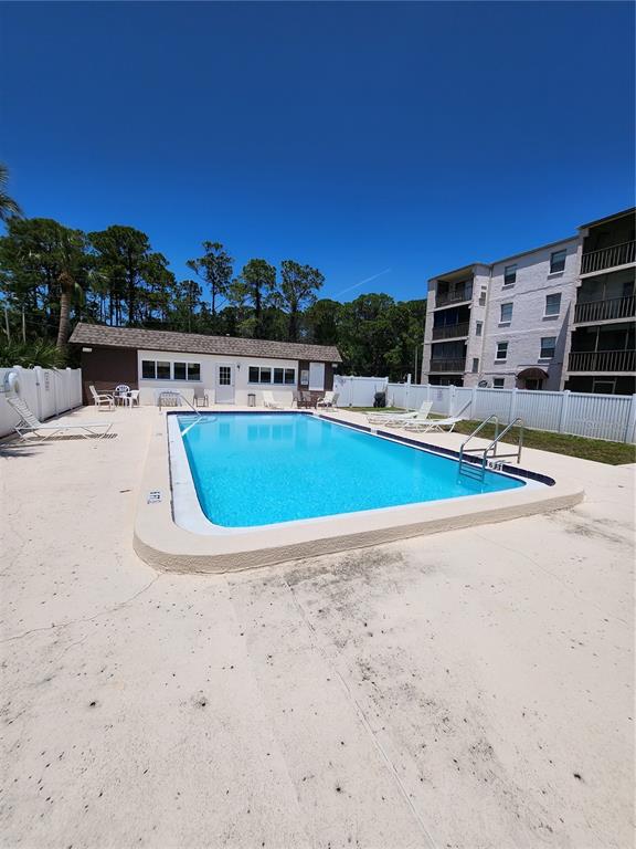 5541 Bay Boulevard, Unit 403 Port Richey, FL 34668 - Photo 23 of 24 a view of a swimming pool with a lawn chairs and a fire pit
