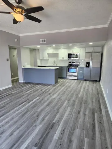 a open kitchen with stainless steel appliances kitchen island granite countertop a stove a sink and a refrigerator