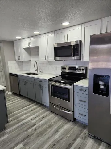 a kitchen with stainless steel appliances a stove microwave and cabinets