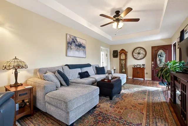a living room with furniture a clock on wall and a chandelier