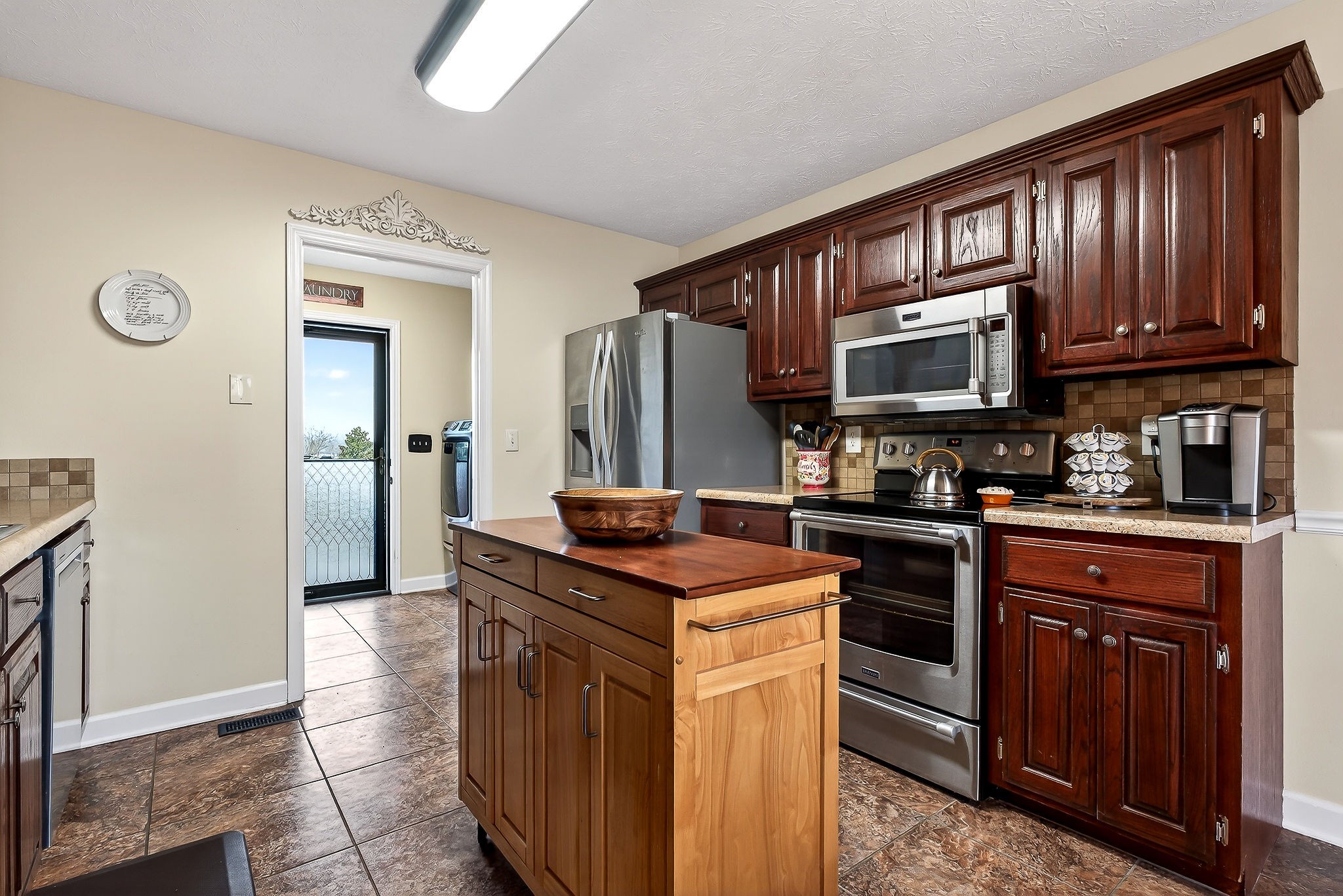 1445 Tom Grissom Road Morrison, TN 37357 - Photo 6 of 42 a kitchen with stainless steel appliances granite countertop a stove top oven a sink dishwasher and a refrigerator with wooden cabinets