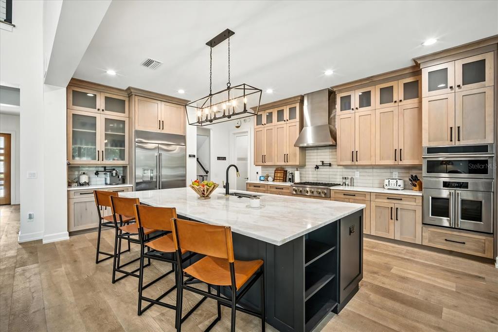 8317 Alafia Pointe Drive Riverview, FL 33578 - Photo 15 of 47 a kitchen with stainless steel appliances granite countertop a stove top oven a sink dishwasher and a dining table with wooden floor