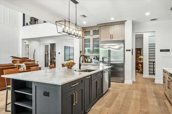 a kitchen with stainless steel appliances granite countertop a stove a sink and a white cabinets