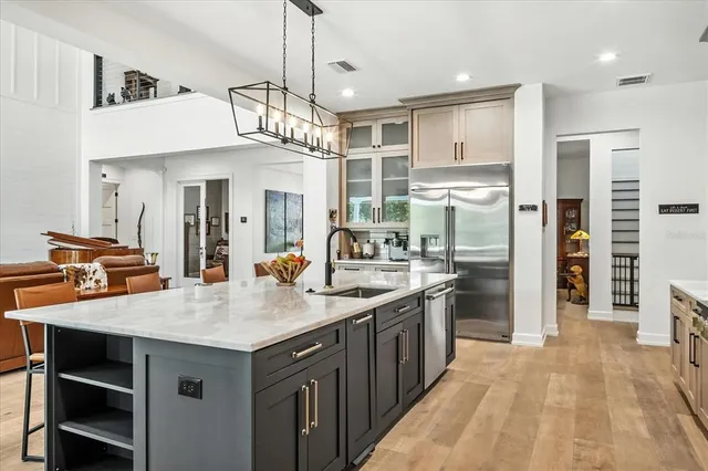 a kitchen with stainless steel appliances granite countertop a stove a sink and a white cabinets