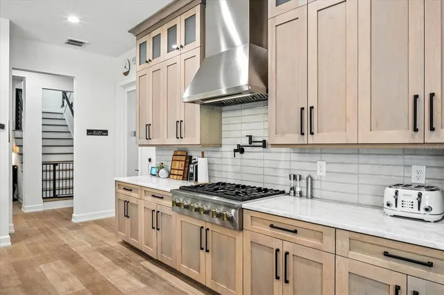 a view of living room with kitchen island furniture a flat screen tv and a large window
