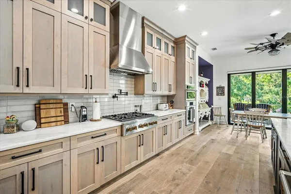 a dining room with wooden floor a chandelier a wooden table and chairs
