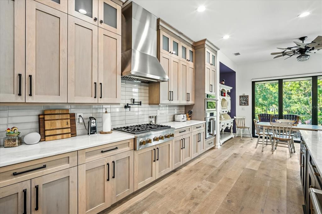 8317 Alafia Pointe Drive Riverview, FL 33578 - Photo 19 of 47 a kitchen with stainless steel appliances granite countertop a stove a sink dishwasher and white cabinets with wooden floor next to windows