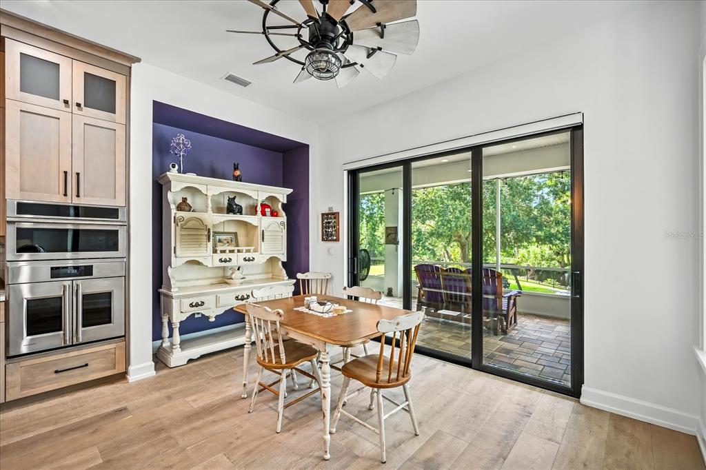 8317 Alafia Pointe Drive Riverview, FL 33578 - Photo 20 of 47 a dining room with wooden floor a chandelier a wooden table and chairs