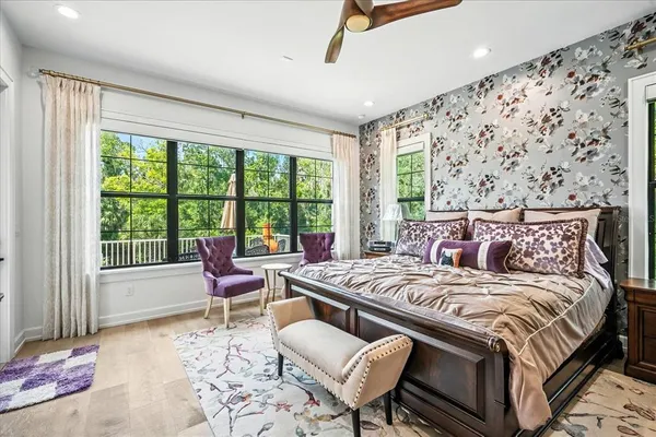 a bedroom with a bed a couch and a flat tv screen