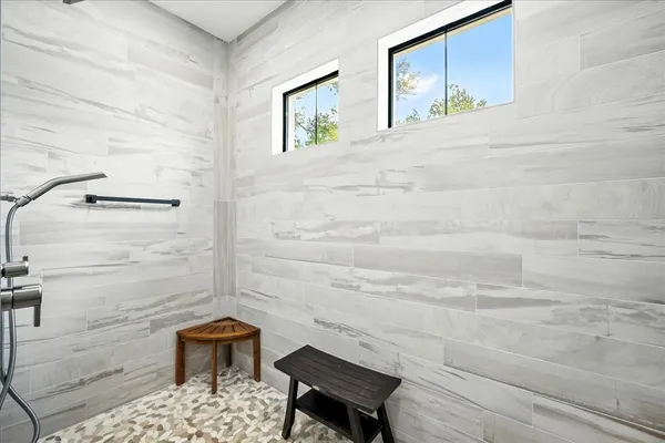 a kitchen with stainless steel appliances a dining table chairs and window