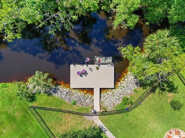 an aerial view of a houses with a yard and lake view