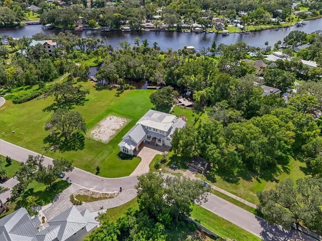 an aerial view of a house with a yard and lake view