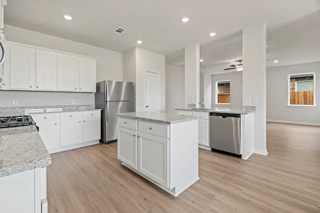 a kitchen with white cabinets sink and stainless steel appliances