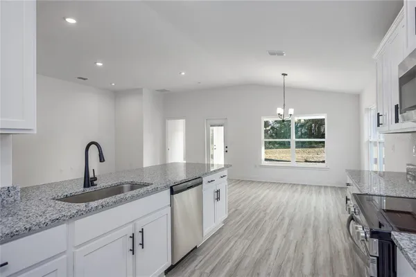 a kitchen with a sink and wooden floor