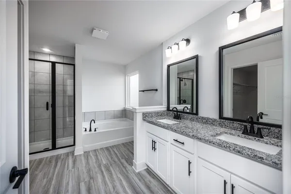 a bathroom with a granite countertop sink mirror and bathtub