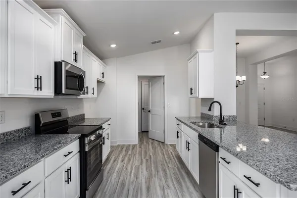 a kitchen with stainless steel appliances granite countertop a stove a sink and a refrigerator