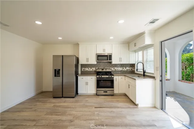 a kitchen with stainless steel appliances granite countertop a refrigerator stove and sink