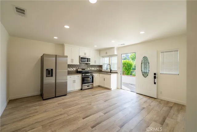 a kitchen with a refrigerator and a stove top oven