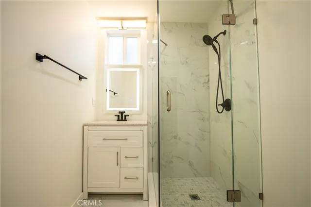 a bathroom with a shower sink and mirror