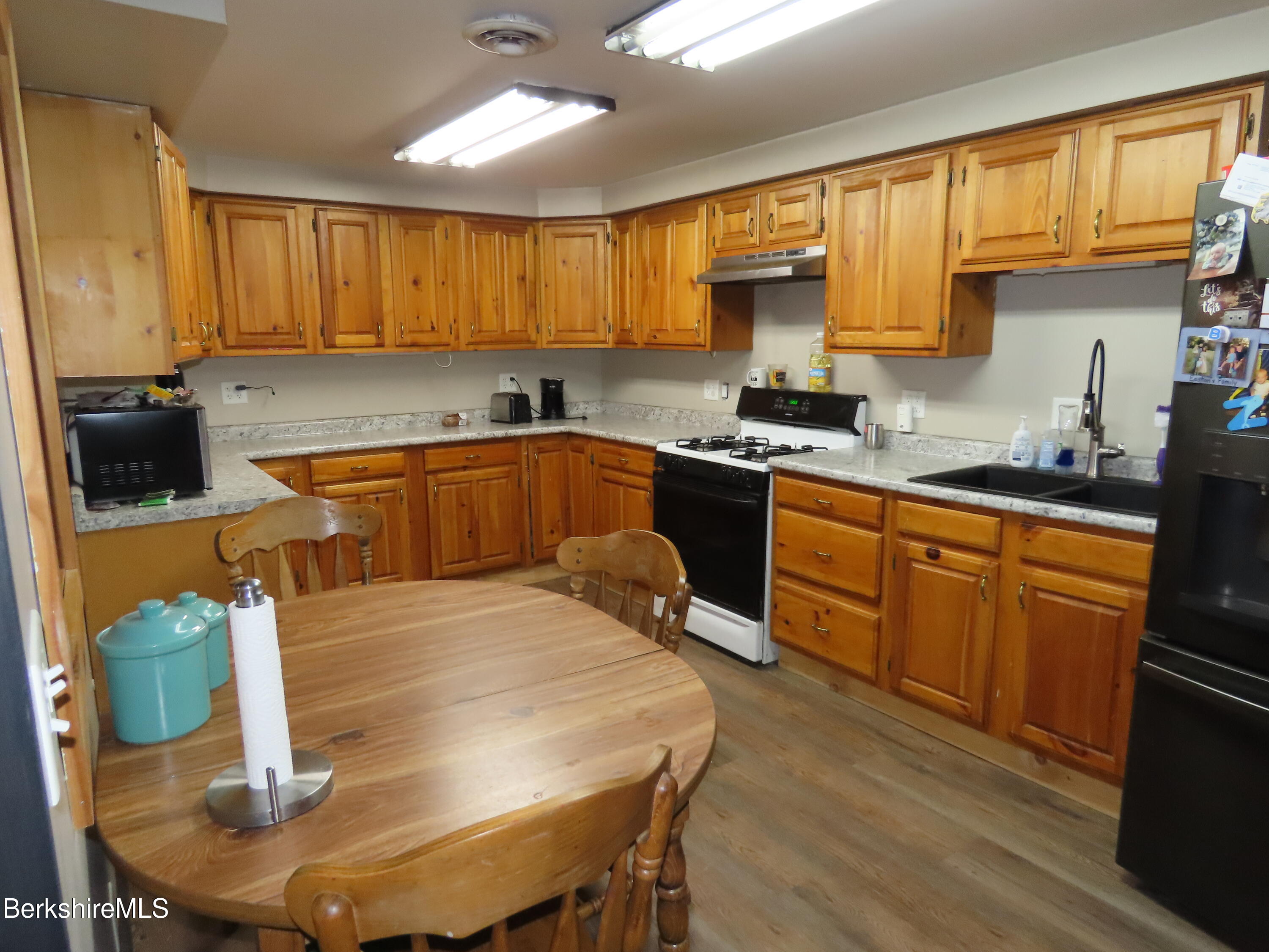 864 E Road Stamford, VT 05352 - Photo 12 of 33 a kitchen with stainless steel appliances granite countertop a stove a sink a microwave refrigerator and chairs