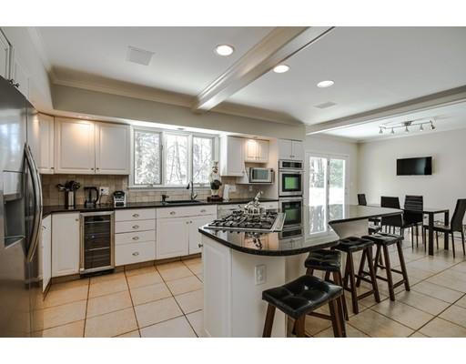 73 Pheasant Landing Road Needham, MA 02492 - Photo 9 of 23 a kitchen with stainless steel appliances kitchen island granite countertop a stove a sink a dining table and chairs