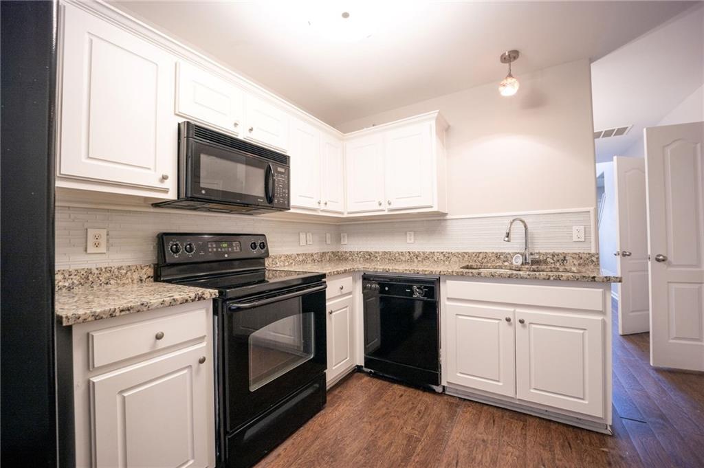 1468 Box Circle Winder, GA 30680 - Photo 10 of 33 a kitchen with stainless steel appliances granite countertop a stove top oven a sink dishwasher and a microwave oven with wooden floor
