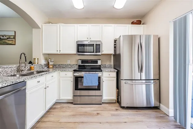 a kitchen with granite countertop a refrigerator stove and microwave