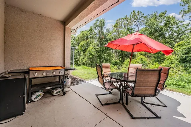 a view of a patio with a table and chairs under an umbrella