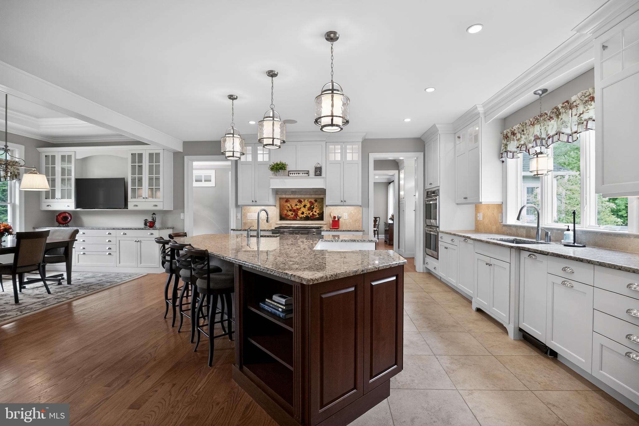 1031 Coates Road Jenkintown, PA 19046 - Photo 18 of 66 a kitchen with granite countertop center island wooden floor and stainless steel appliances