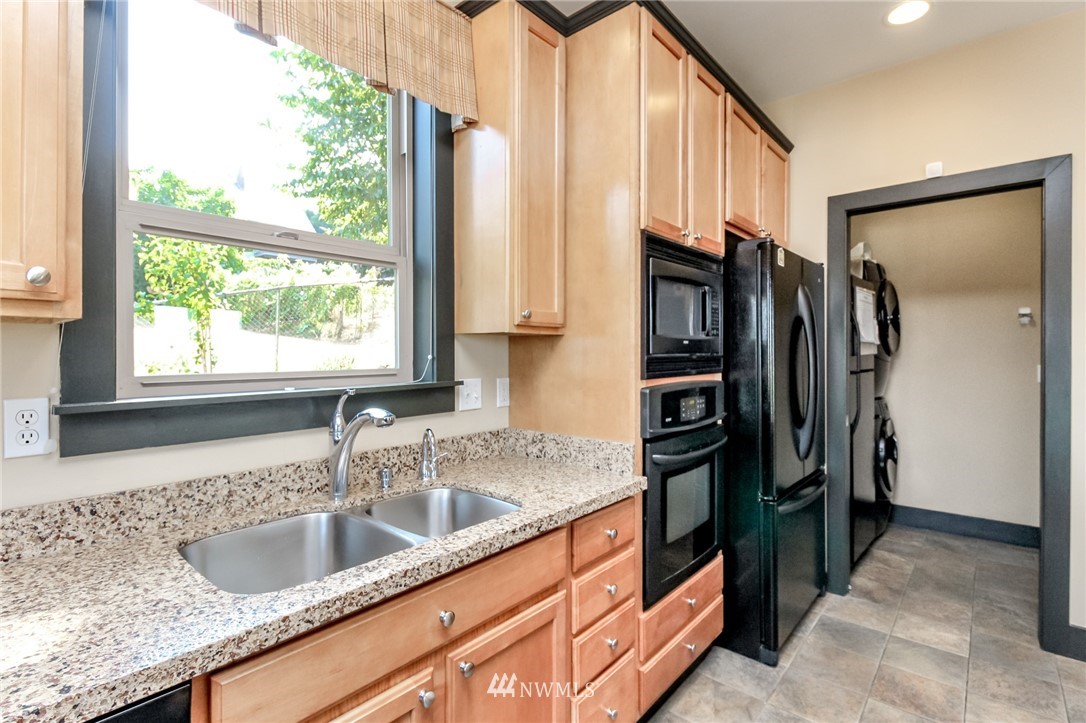 1203 South 3rd Street Renton, WA 98057 - Photo 12 of 40 a kitchen with stainless steel appliances granite countertop a sink and a refrigerator