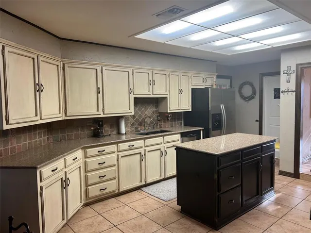 a kitchen with kitchen island granite countertop a sink and white cabinets