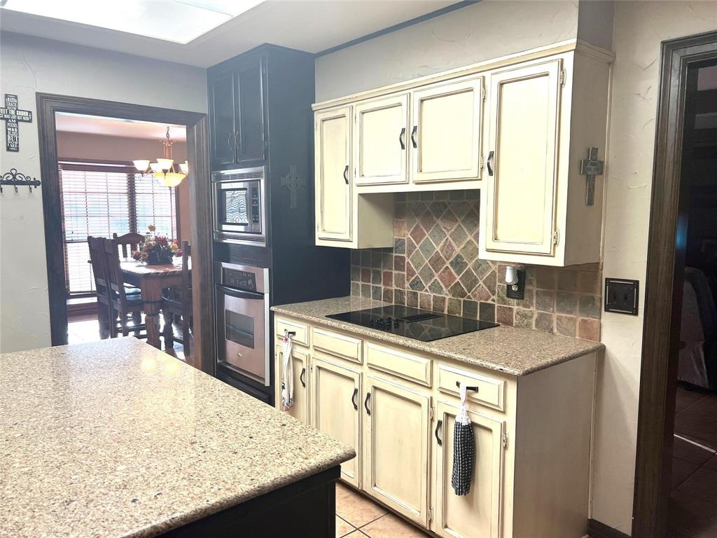 2815 Farm To Market Road 3092 Gainesville, TX 76240 - Photo 8 of 28 a kitchen with kitchen island granite countertop a sink and white cabinets