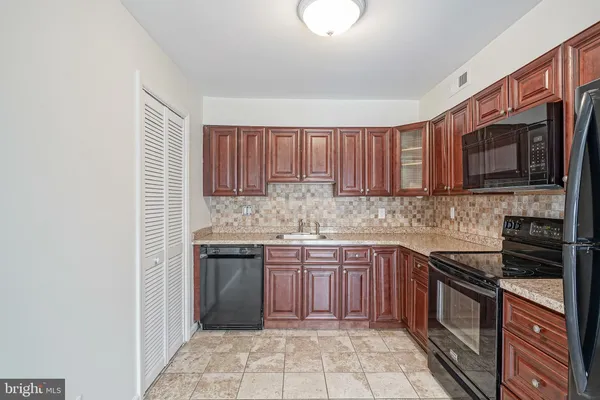 a kitchen with stainless steel appliances granite countertop a stove sink microwave and cabinets