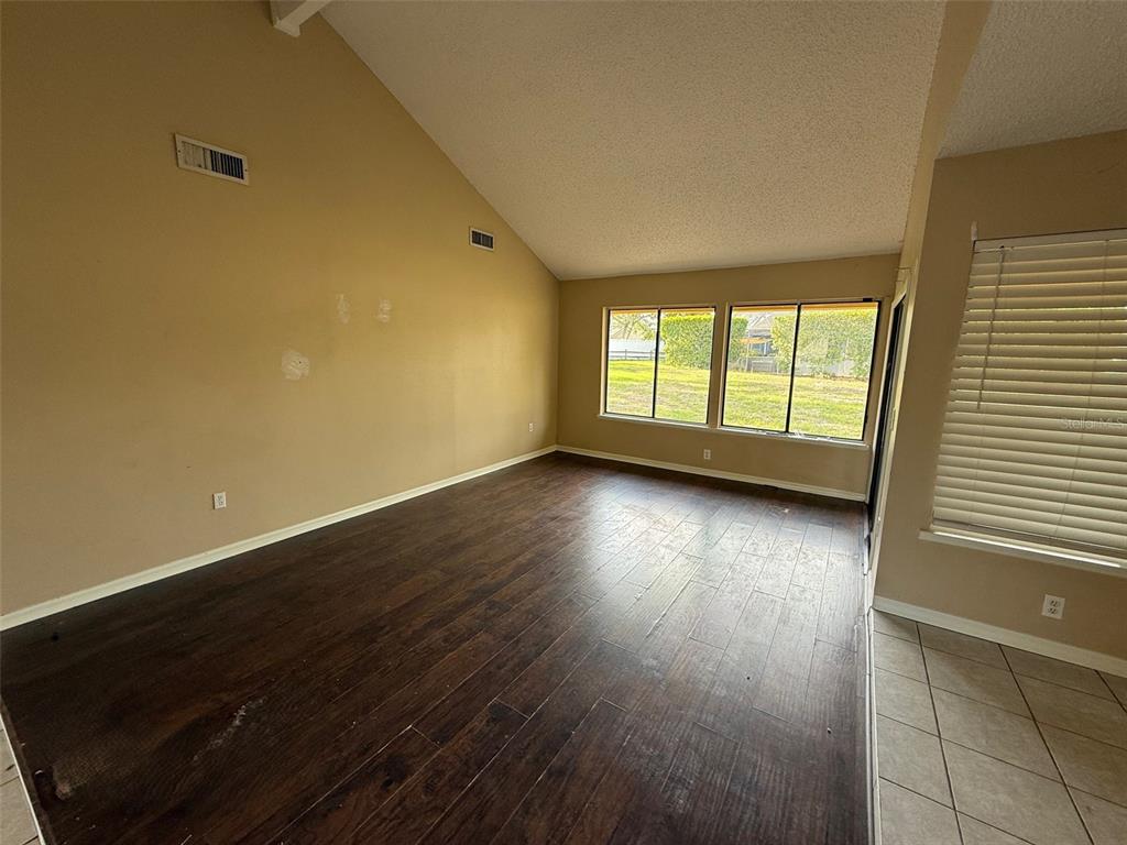 9085 Heather Boulevard Weeki Wachee, FL 34613 - Photo 2 of 15 an empty room with wooden floor and windows