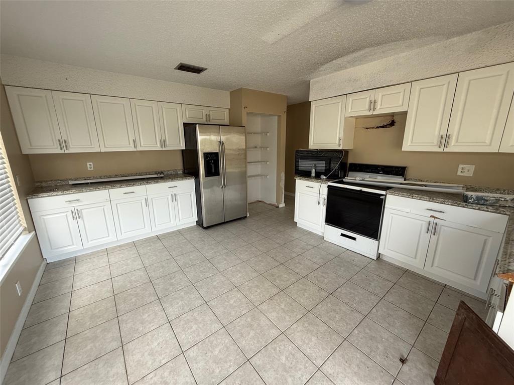 9085 Heather Boulevard Weeki Wachee, FL 34613 - Photo 5 of 15 a kitchen with stainless steel appliances granite countertop a stove a sink and a refrigerator