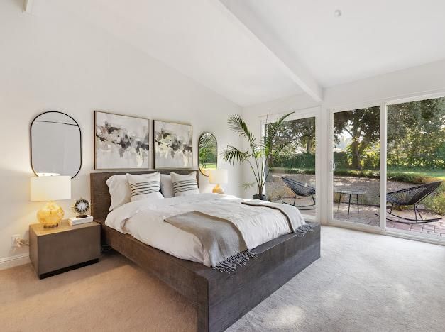 a bedroom with a bed and a large window