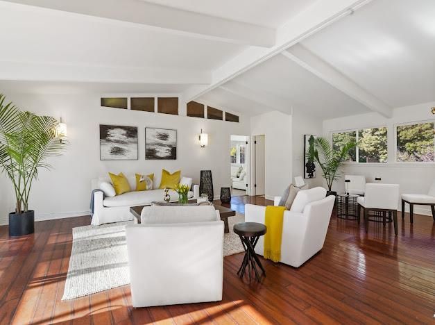 a living room with furniture wooden floor and a potted plant