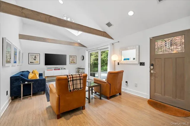 a living room with furniture wooden floor and a flat screen tv