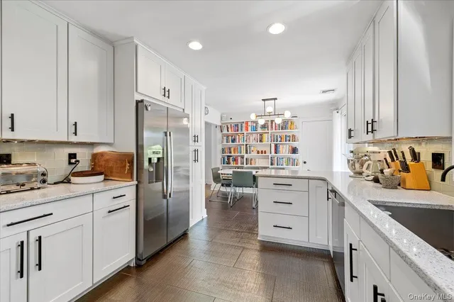 a kitchen with white cabinets and refrigerator