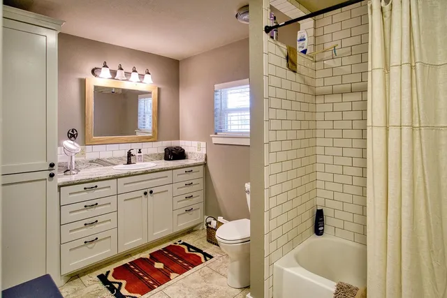 a bathroom with a double vanity sink mirror and toilet