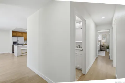 a view of a hallway with bathroom and wooden floor